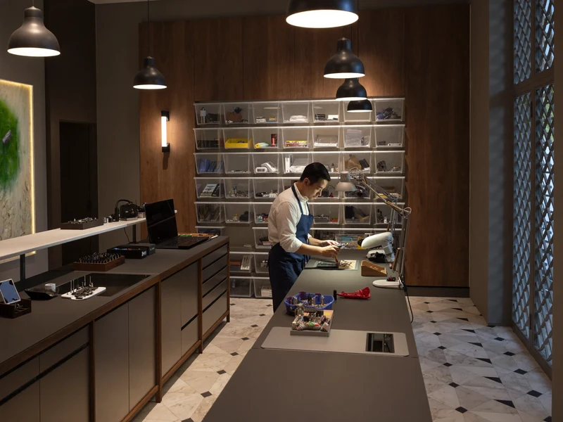 Illustration d'un atelier parisien lumineux où un technicien travaille à son établi.